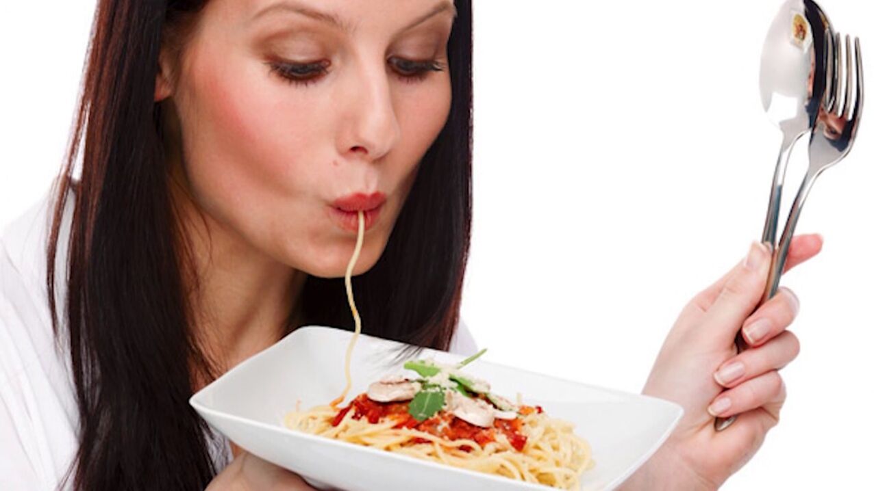 kvinna som äter spagetti för att banta magen